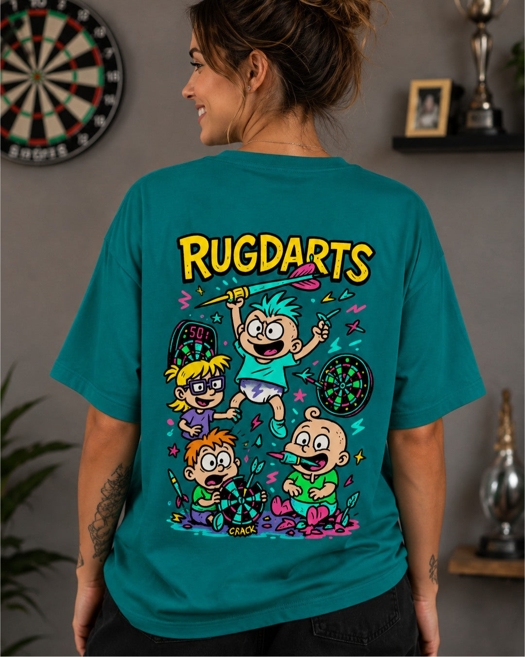 Chica de espaldas con la camiseta de dardos Rugdarts turquesa y el diseño de bebés con dardos en la espalda