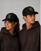 Chica y chico con la gorra de dardos Rugdarts negra y el diseño de bebés con dardos en el frontal